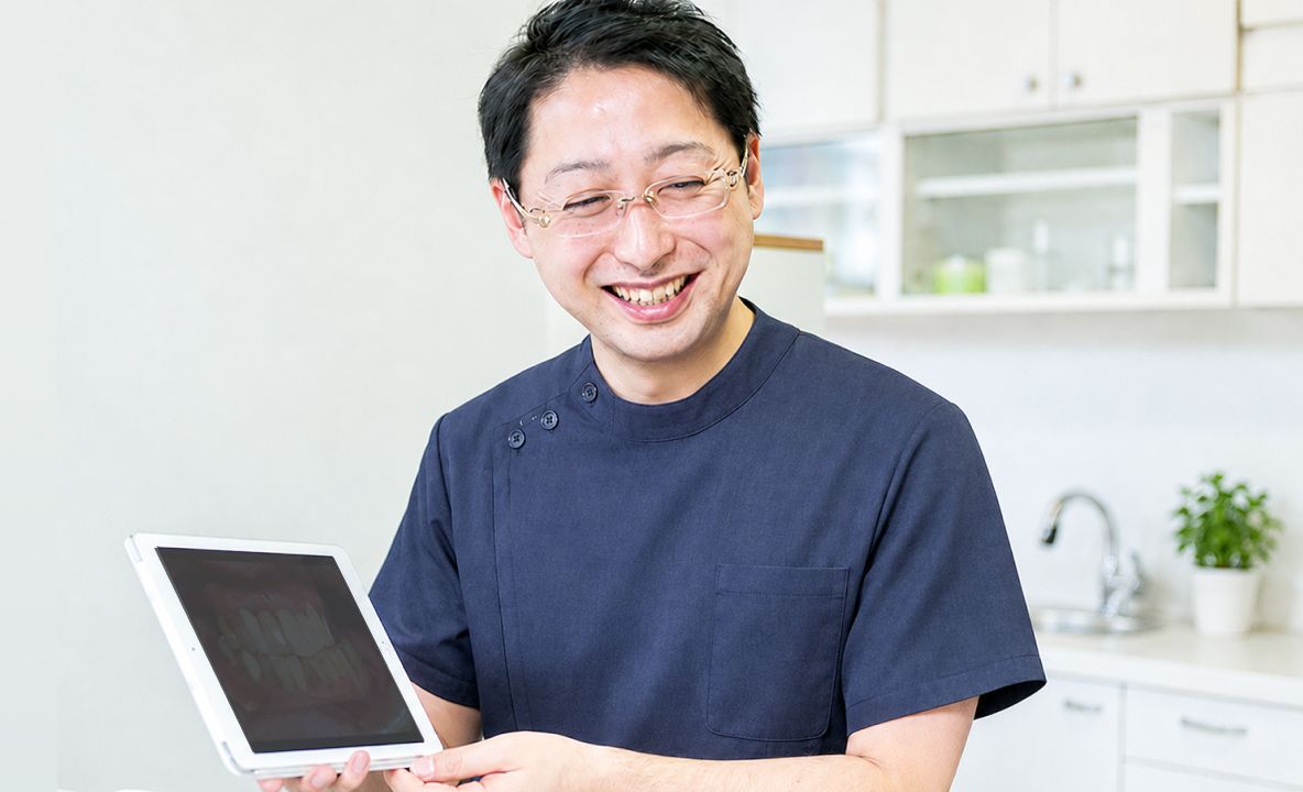 タブレットを手に説明する歯科医師