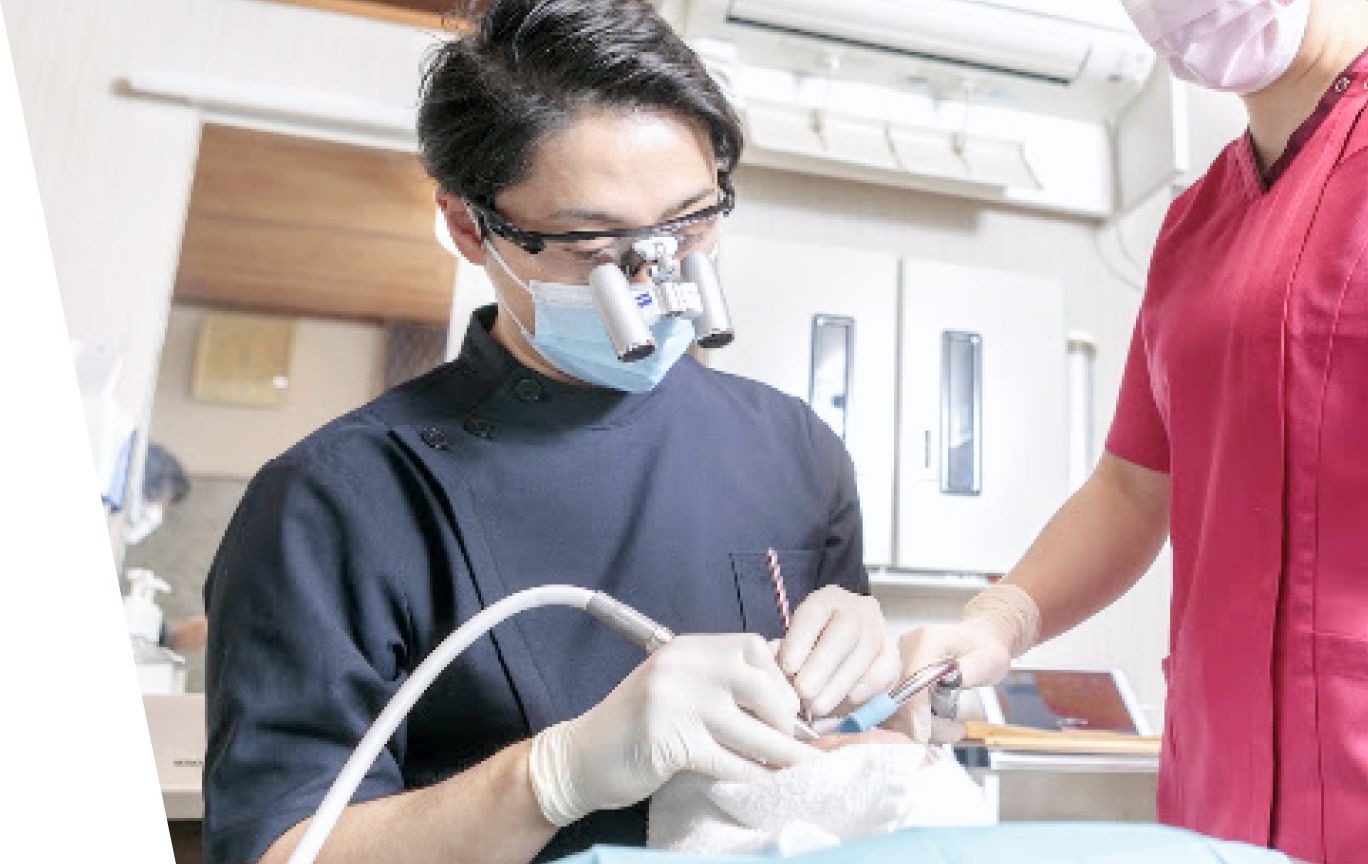 患者の治療を行う歯科医師とスタッフ
