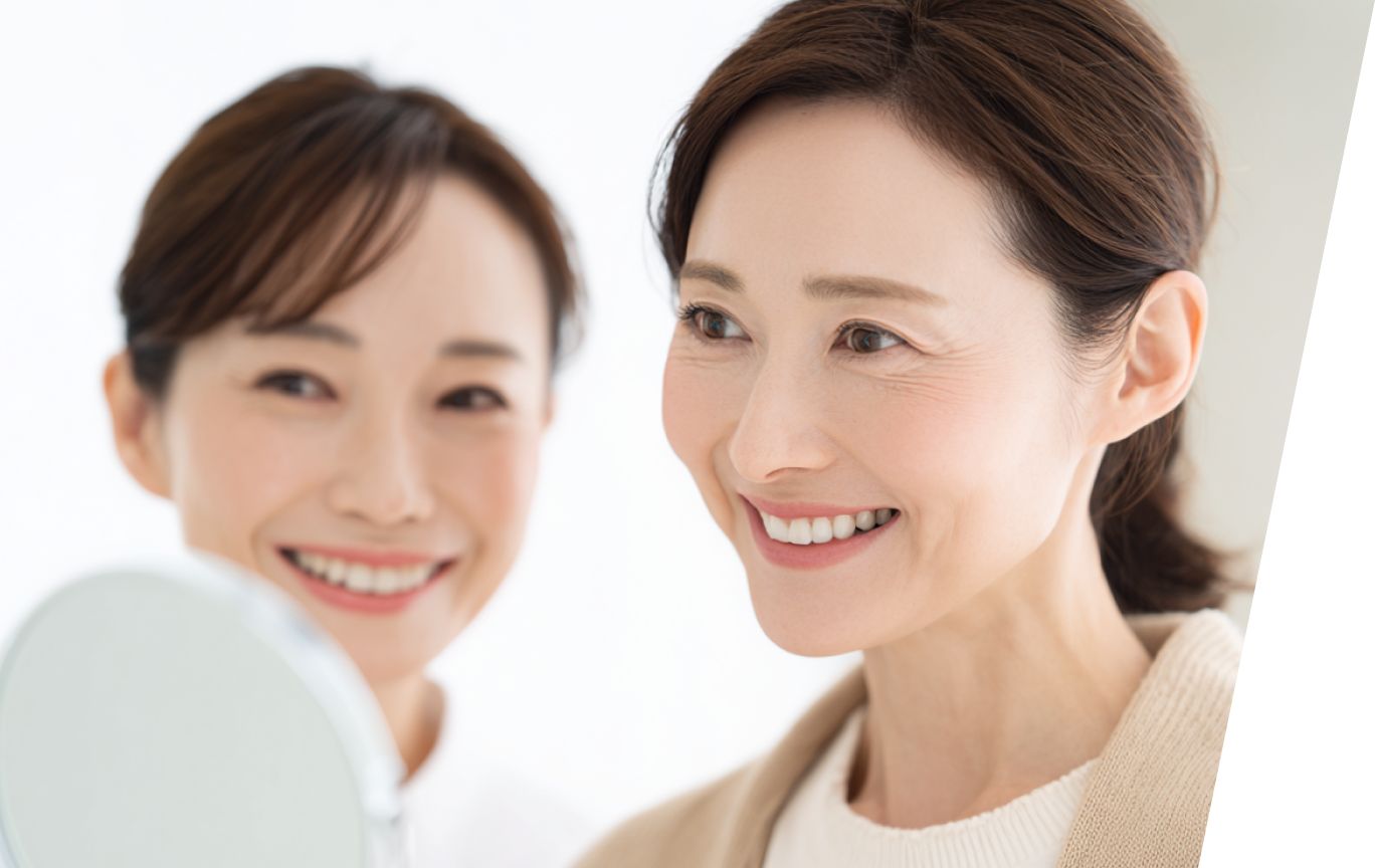鏡を見て笑顔を見せる女性とスタッフ